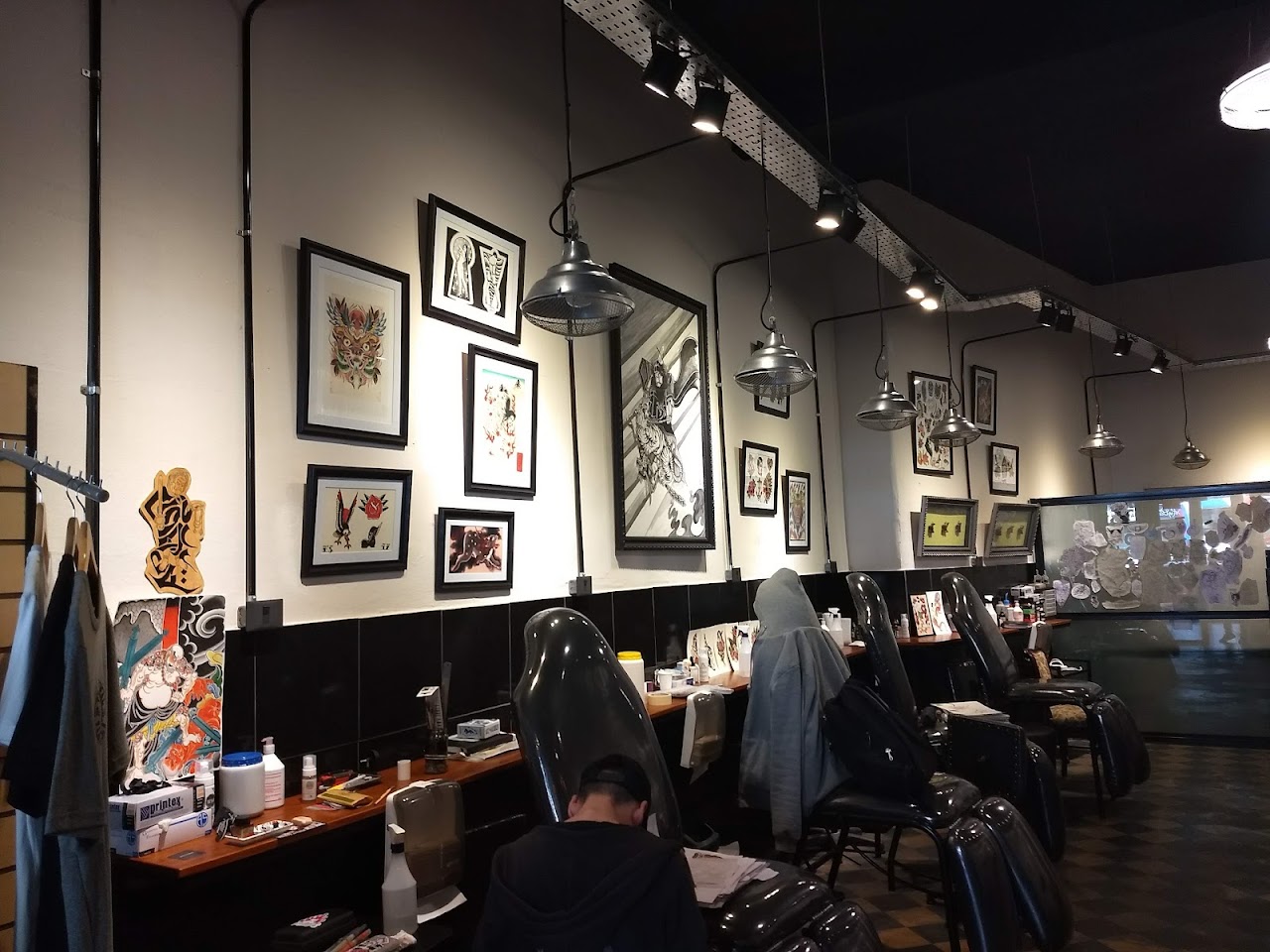 Sala de tatuaje de UKATATA con estaciones y arte en la pared